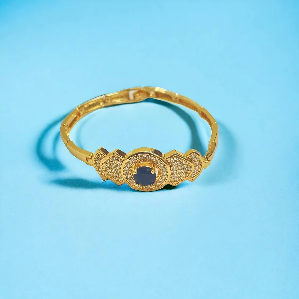 Golden Elegance: Intricately Designed Bracelet with Central Gemstone and Sparkling Accents
