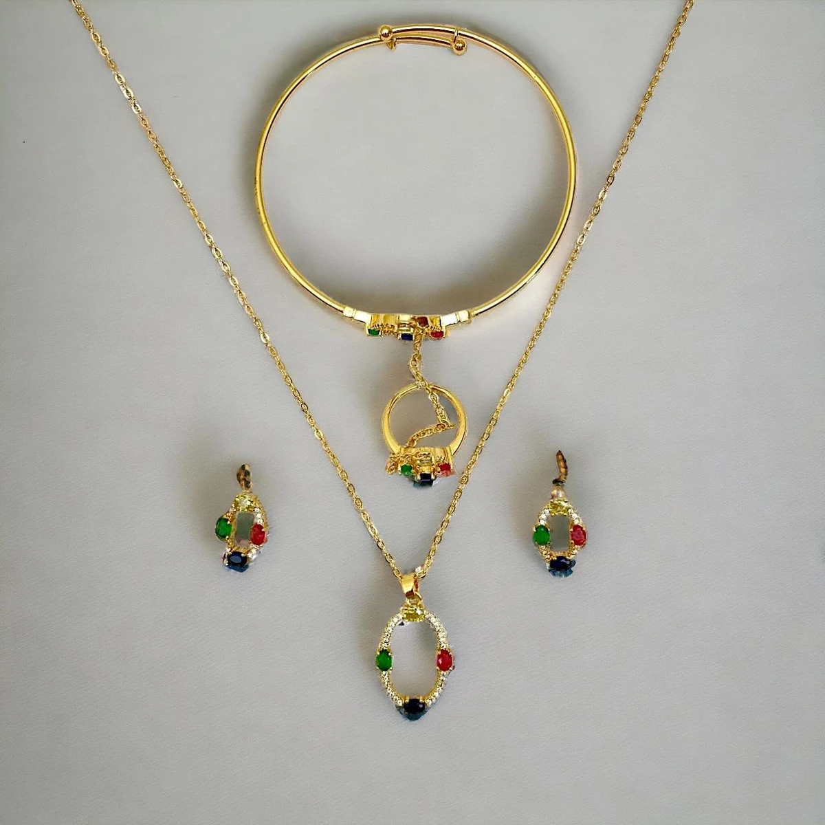 Prism of Elegance: Luxurious Gold Necklace, Ring, and Earrings Bedecked with Luminous Gemstones